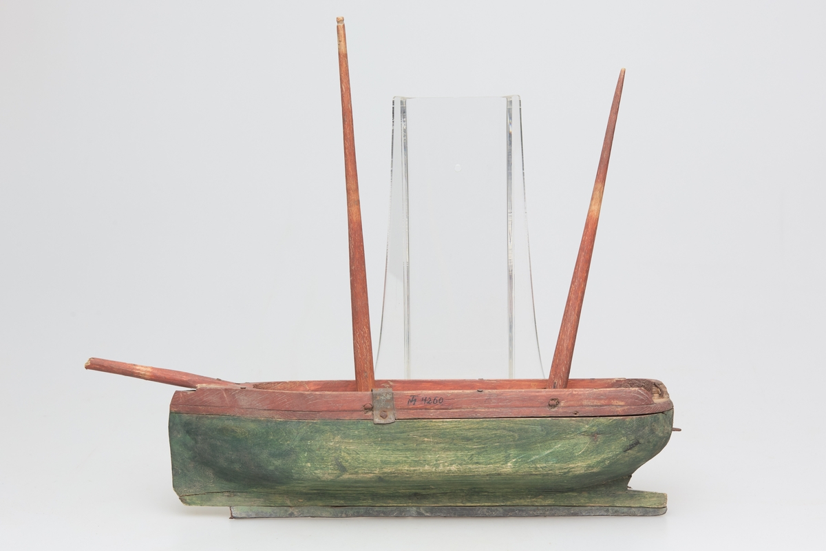 Rød og grønnmalt båt med en blystang under kjølen.