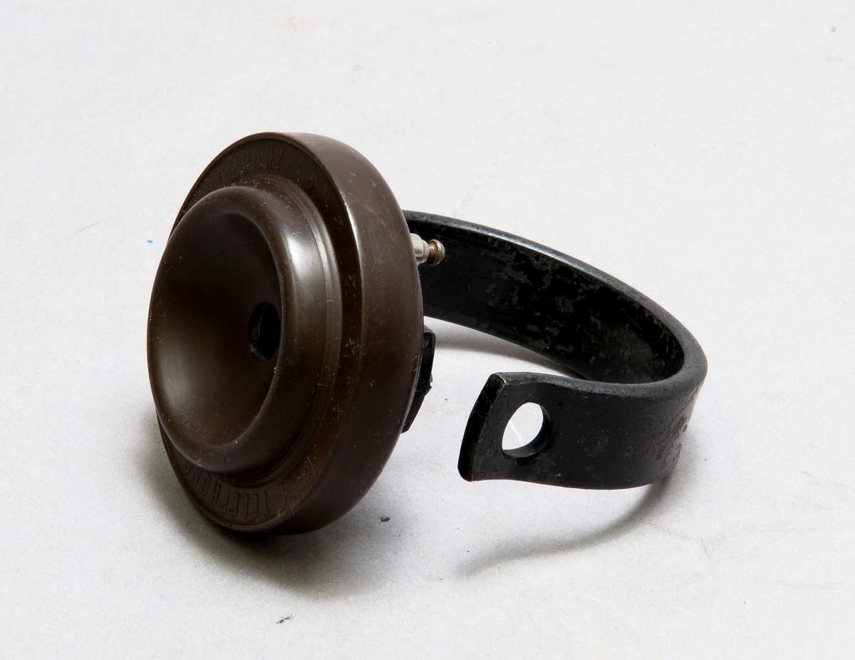 Hörtelefon märkt "Bell Telephone Manufactruing Company", med magneten böjd till handtag. Även märkt 911.