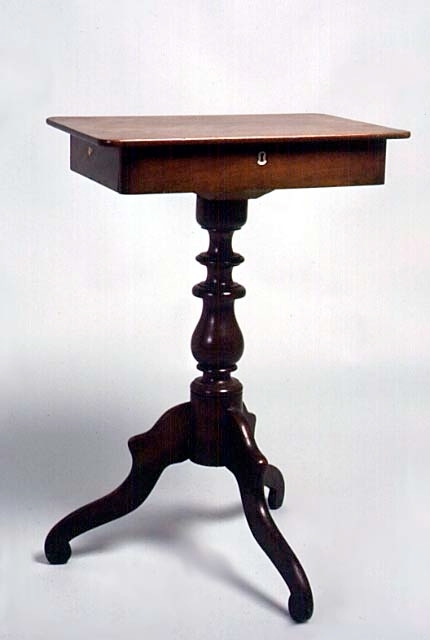 Sybord; rektangulärt. I sargen en låda med ett stort fack och tre små. Skulpterad, balusterformad mittpelare. Tre stycken mjukt svängda ben. Stilimitation från 1800-talets senare del.