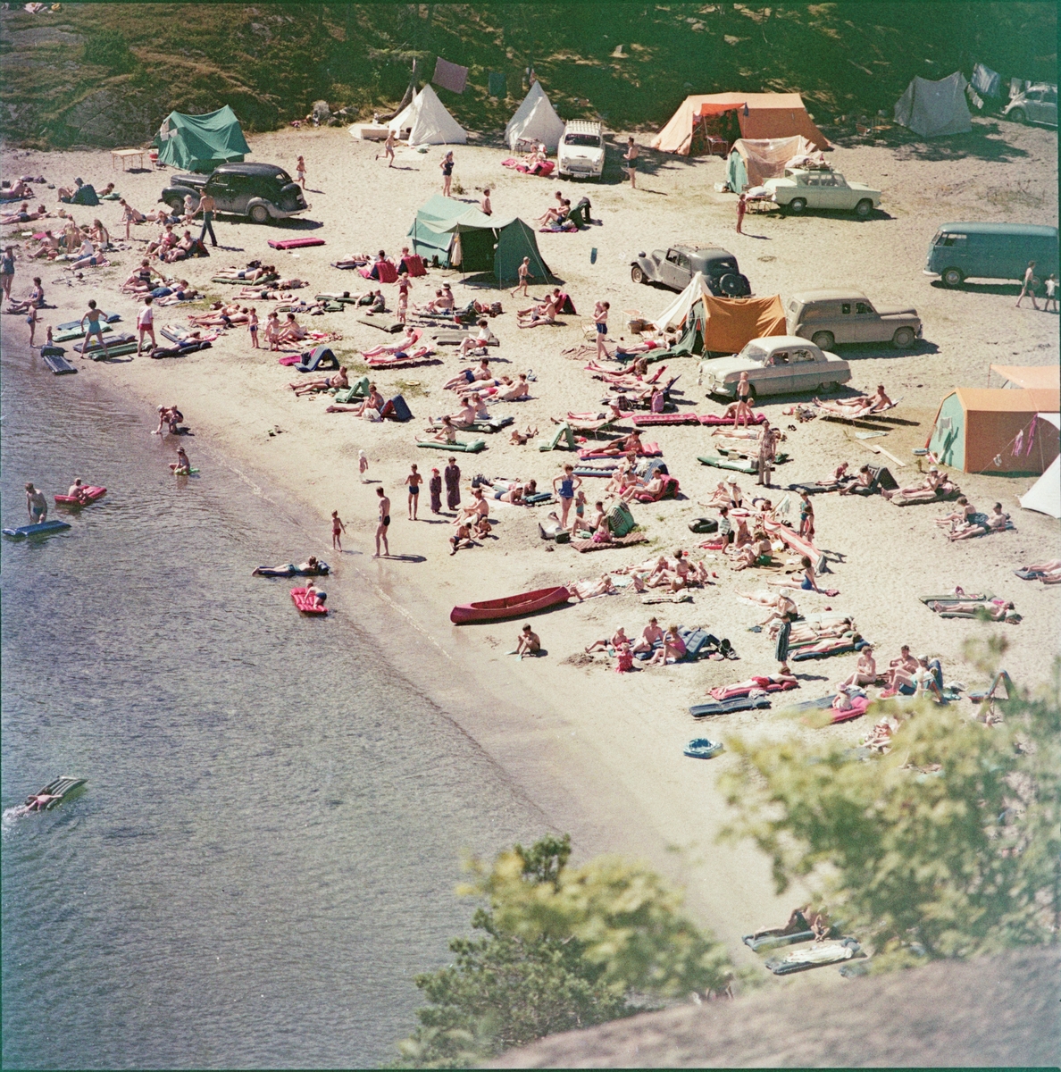 Camping på sørlandet. Oversiktsbilde over stranden med solbadere, båter, bilder og telt. 1961-1963