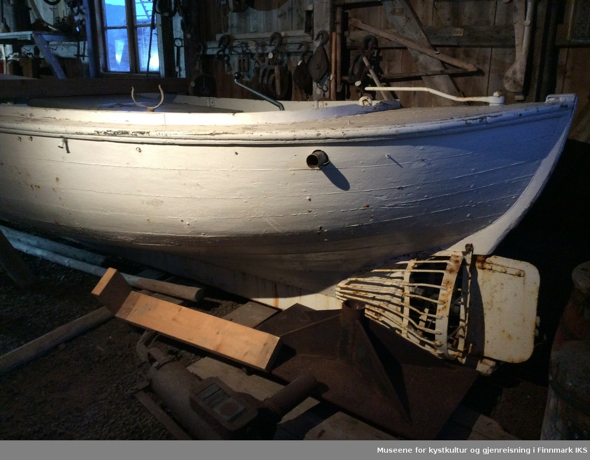Hvit malt kravellbygget båt med  motor. og festeanordninger til 4 årepar.