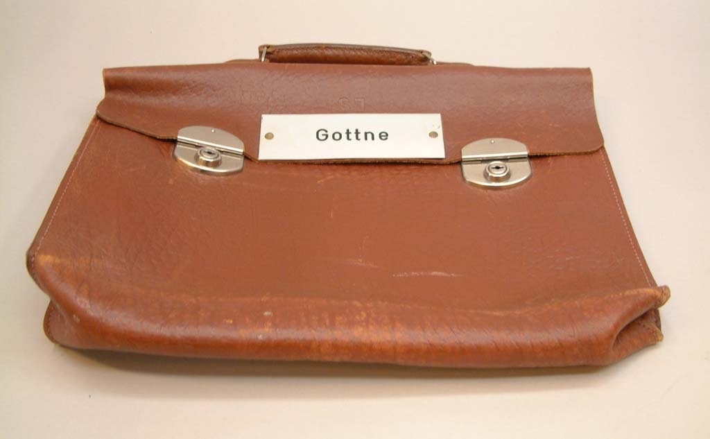 Stationsväska i brunt läder med två lås och två nycklar i portföljen.
Metallskylt med text "GOTTNE"