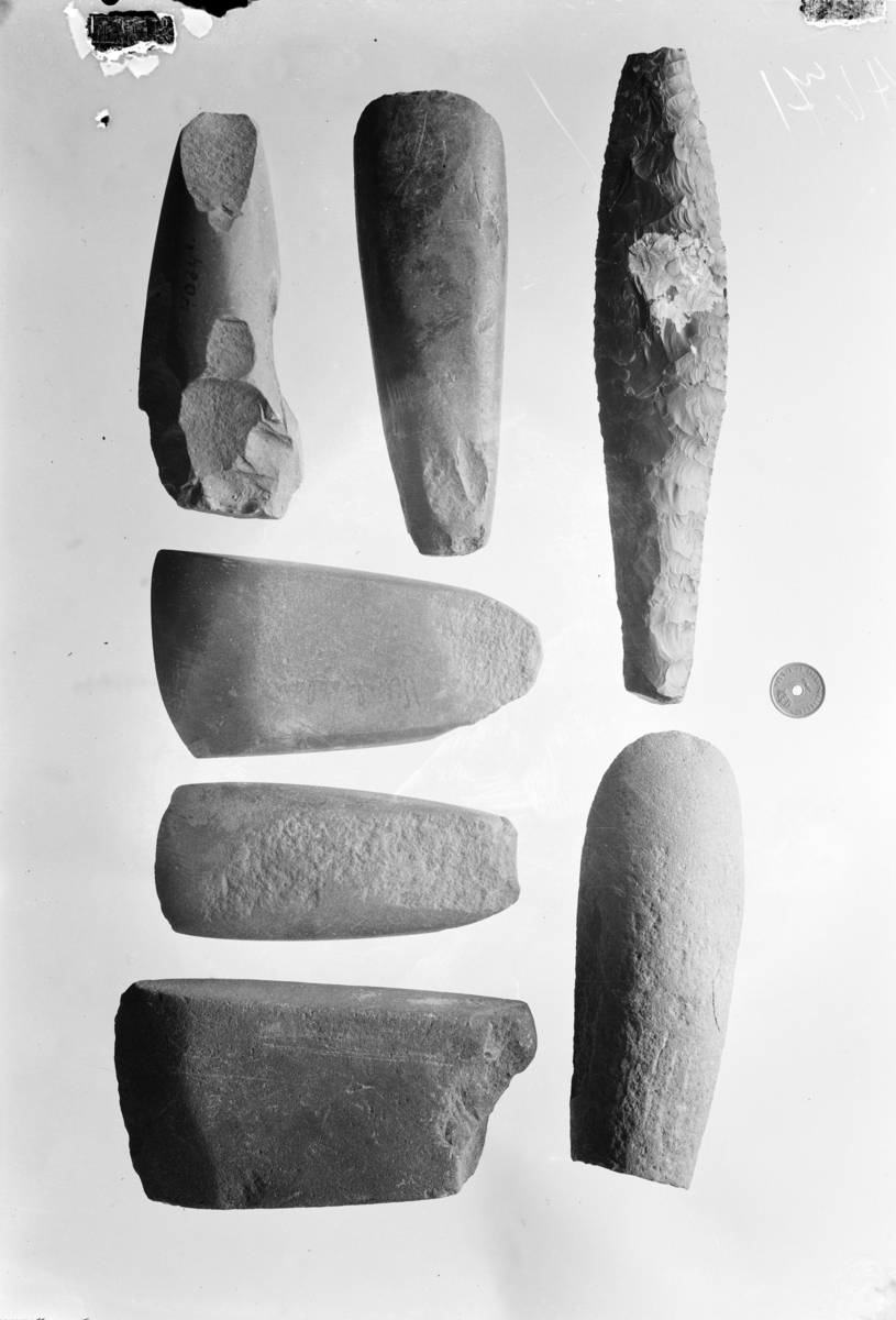 Stenøks av vestlandstype, sl. Gjessing l. c. fig. 98. Et stykke avslått i nakken, ellers vel bevaret, slepet over hele overflaten. Lengde 11,4 cm., største bredde i eggen 5,9 cm. - 