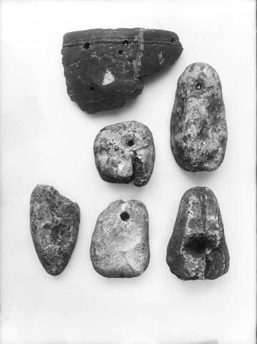 "5190 c. Tre kljåsten er av klebersten (sl. R. 437), den ene fragmentarisk av de ujevne former, som er karakteristisk for vikingetidens kljåstener. Størrelse: 1) 12,4 x 6,4 cm, 2) 9,3 x 7 cm, 3) 7,5 x 7,8 cm (defekt). Sten nr. 2 har tidligere hatt bærehull høiere oppe, men er blitt avbrukket over hullet, hvorpå nytt hull er boret for å utnytte den tildannede sten (Gamle gårdsanlegg 1936, pl. XXXIX, fig. 1-3)." I samsvar med beskrivelsen. Vevlodd nr. 2 har en korsformet figur innskåret like over hullet. Nr 3 (fnr. 159) er 80 x 82 mm, et hjørne er slått av og ligger løst.