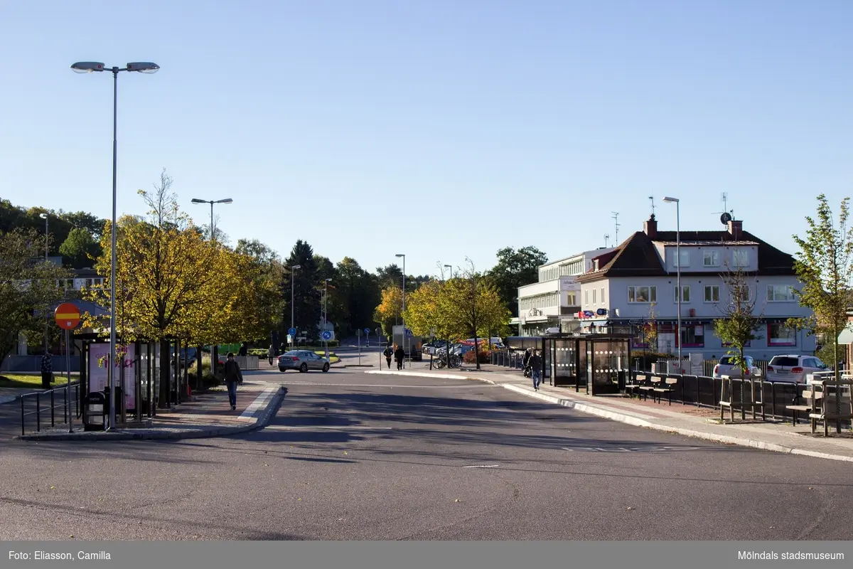Kållereds centrum den 6 oktober 2016. Gamla Riksvägen i rktning söderut. Busshållplatser i anslutning till Kållereds station. Till höger ses servicebutiken i huset Gamla Riksvägen 48 A samt även huset 48 B.