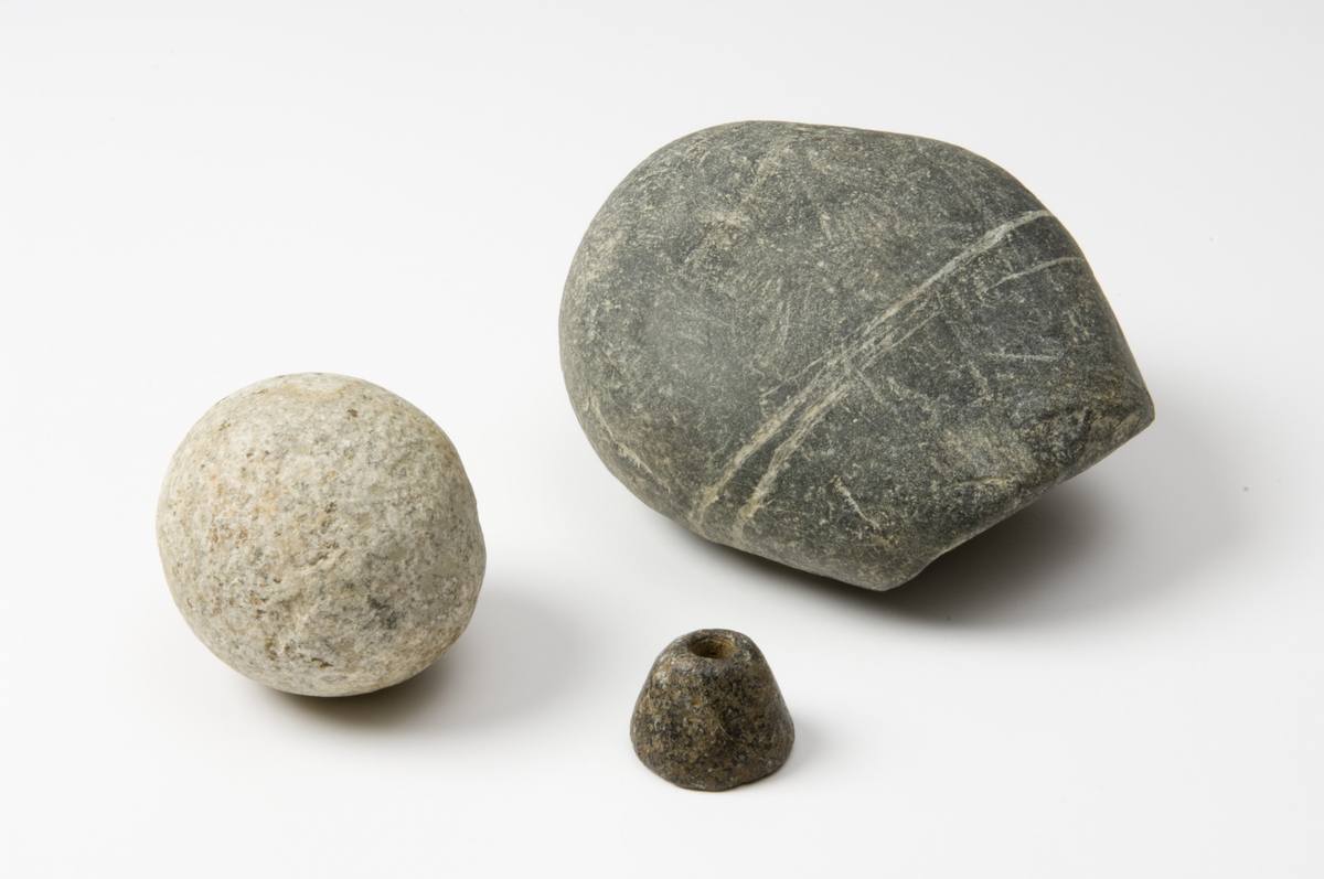 c. Løper til skubbekvern. Stor oval stein i grå bergart med en skråstilt slipeflate i den ene enden. St.l. 147 mm, st.b. 123 mm.