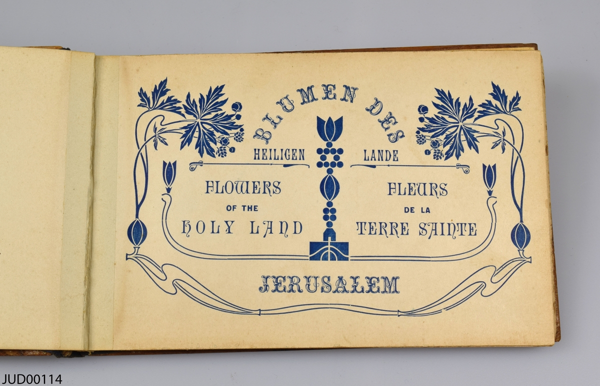 Bok med träpärmar, skriven på ryska, hebreiska, tyska, franska och engelska, med namnet "Blumen des Heiligen Lande / Flowers of the holy land / Fleurs de la terre sainte". Boken innehåller pressade blommor från Jerusalem.