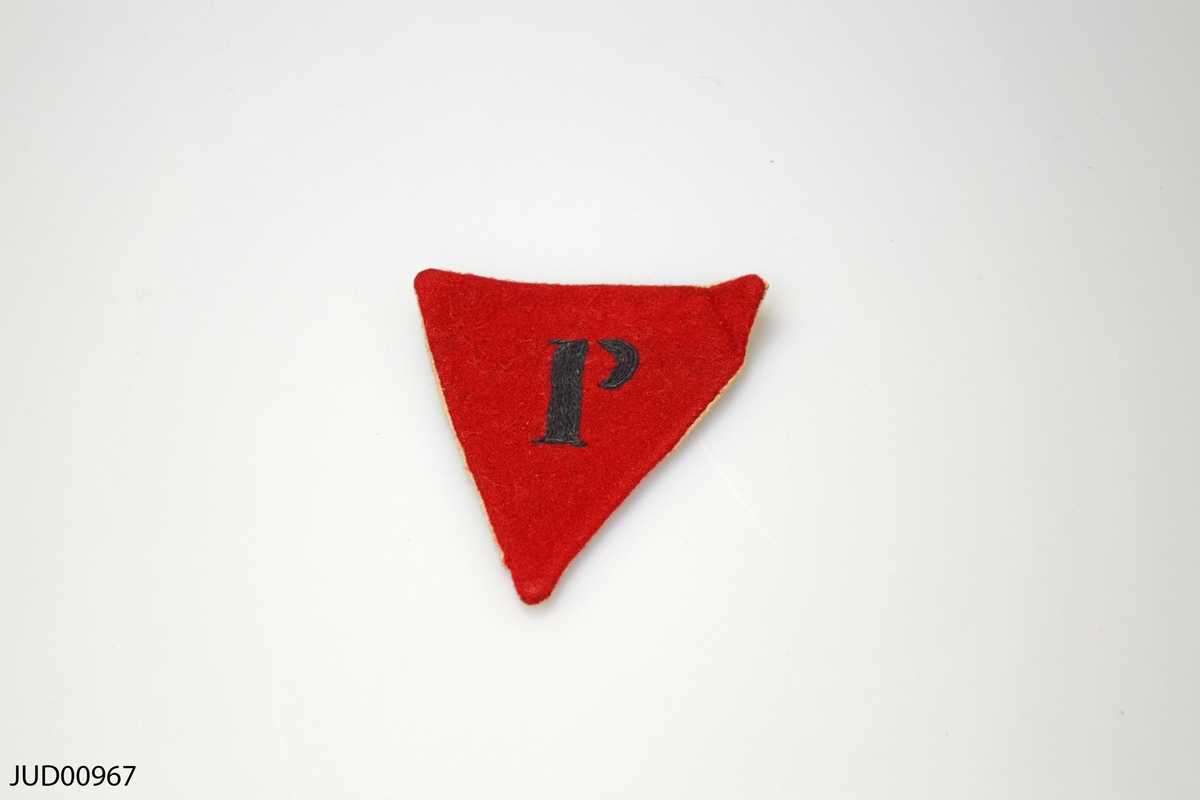 Röd trekantig tygbit med P.