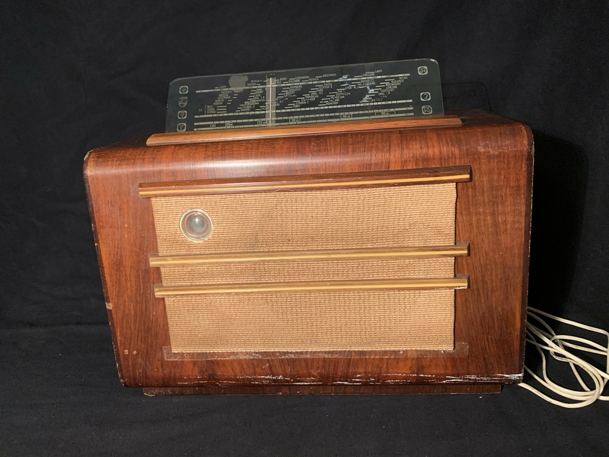 Radioapparat i tre med tekstil framfor høgtalaren inne i apparatet.