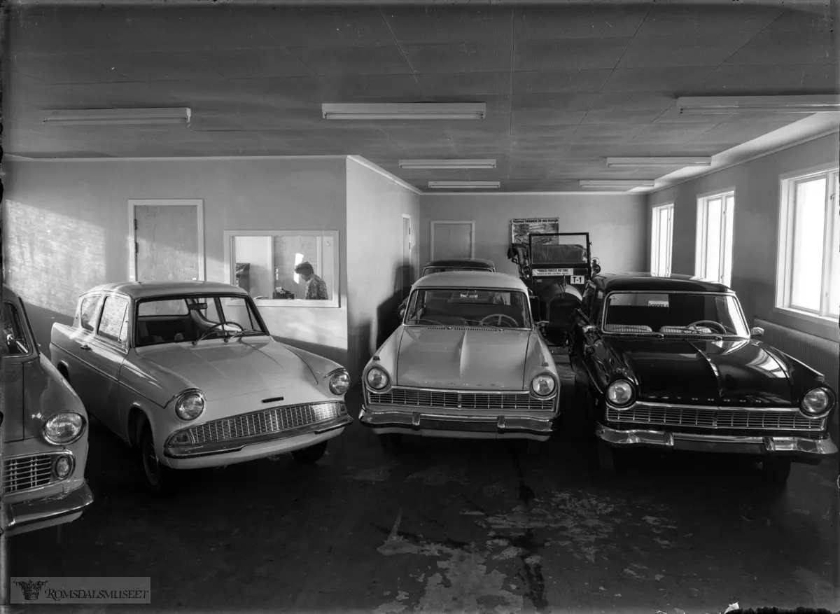 Fra venstre: Ford 12 Super 1958-60, Anglia kom høsten1959 som -60-modell - avløst ca,1966 av Escort. To Taunus 17M 1958-60. Av disse var Anglia den nyeste. I bakgrunnn ukjent og T-1 Unic 1908. i loket til Ford-forandler Haukebø og Rødseth.