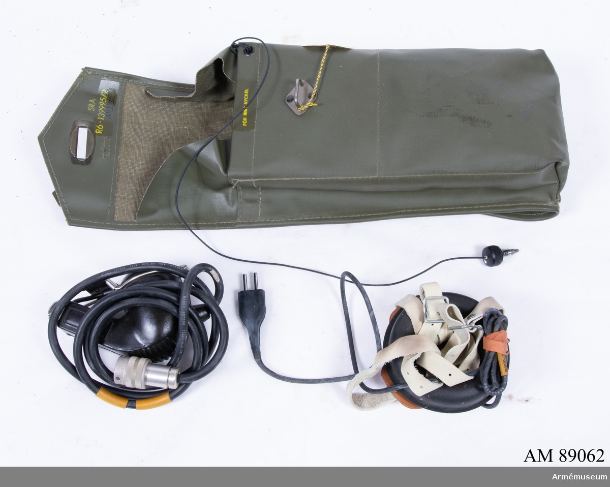 Packficka av grön galonväv. I packfickan: antennsladd, förlängningssladd, hörlur, isärtagbar telefonlur.