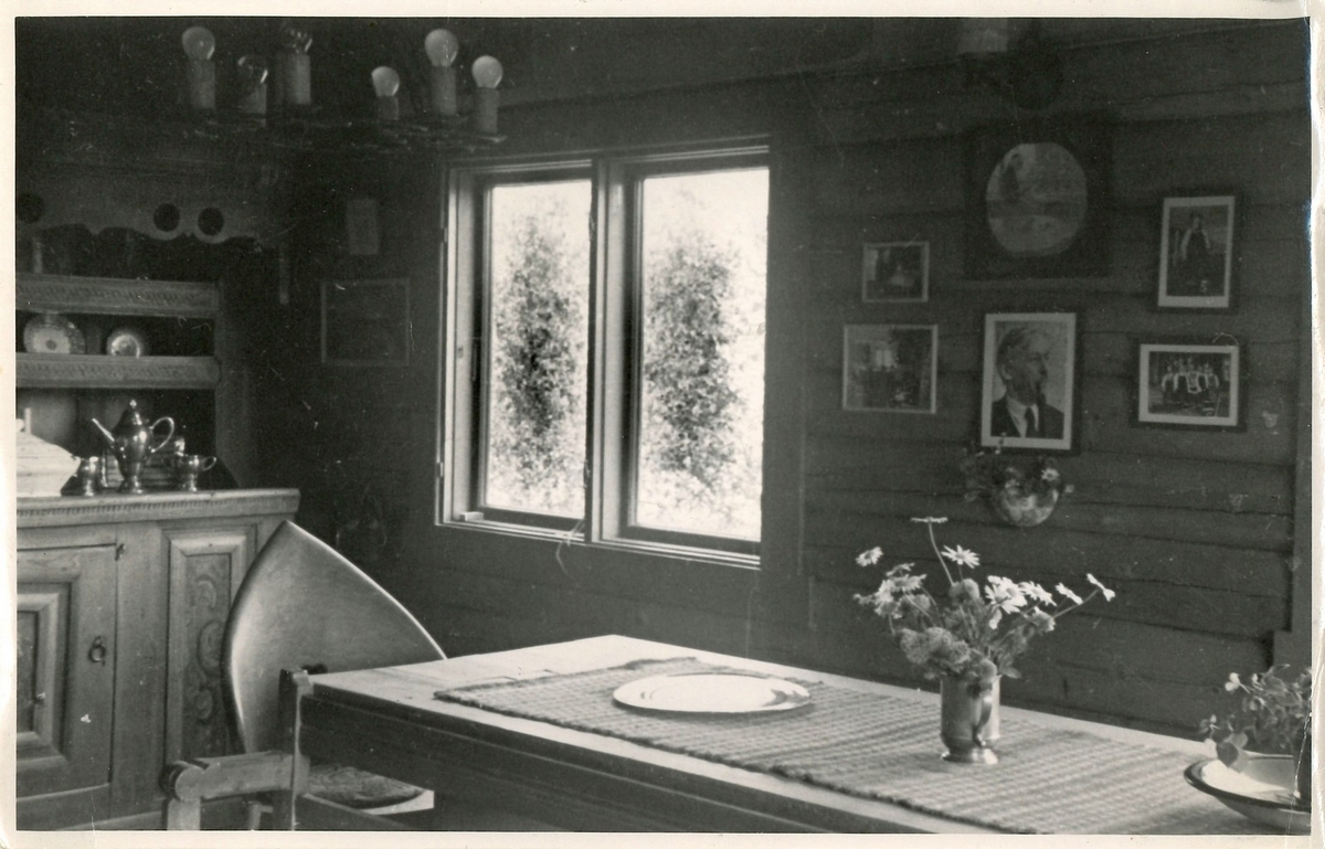 Fotografi av peisestova på Rytterhaugen frå sumaren 1951. Fotografiet er send til Helga og Lars Fossgard med ønskje om ei signa jul frå Hanna Rytter. Far til Hanna Rytter var diktaren Henrik Rytter (1877-1950).