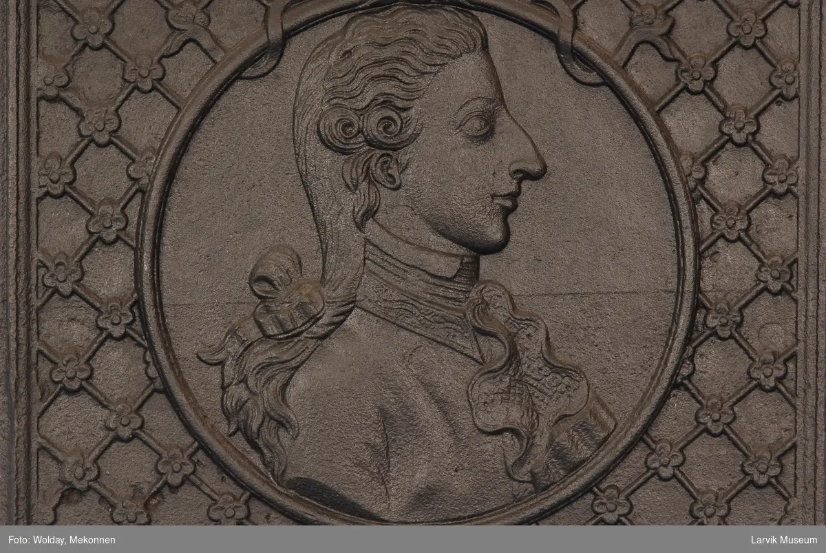 Brystbilde av Fredrik VI som kronprins i profil mot høyre, i rund medaljong. gitret bunn