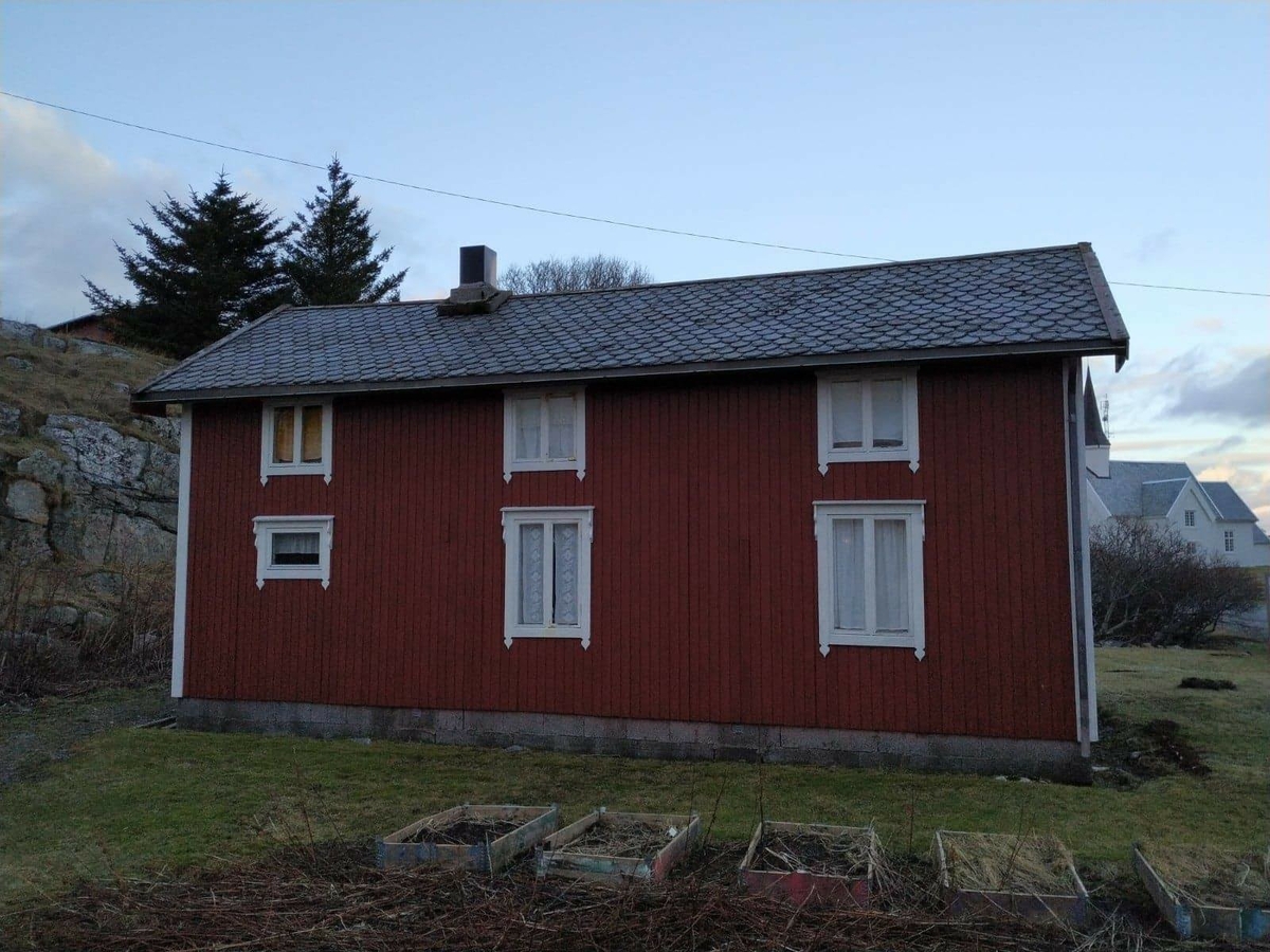 Huset har panel stående panel, malt rødt med hvit dekor på og rundt vinduer. Skifertak.