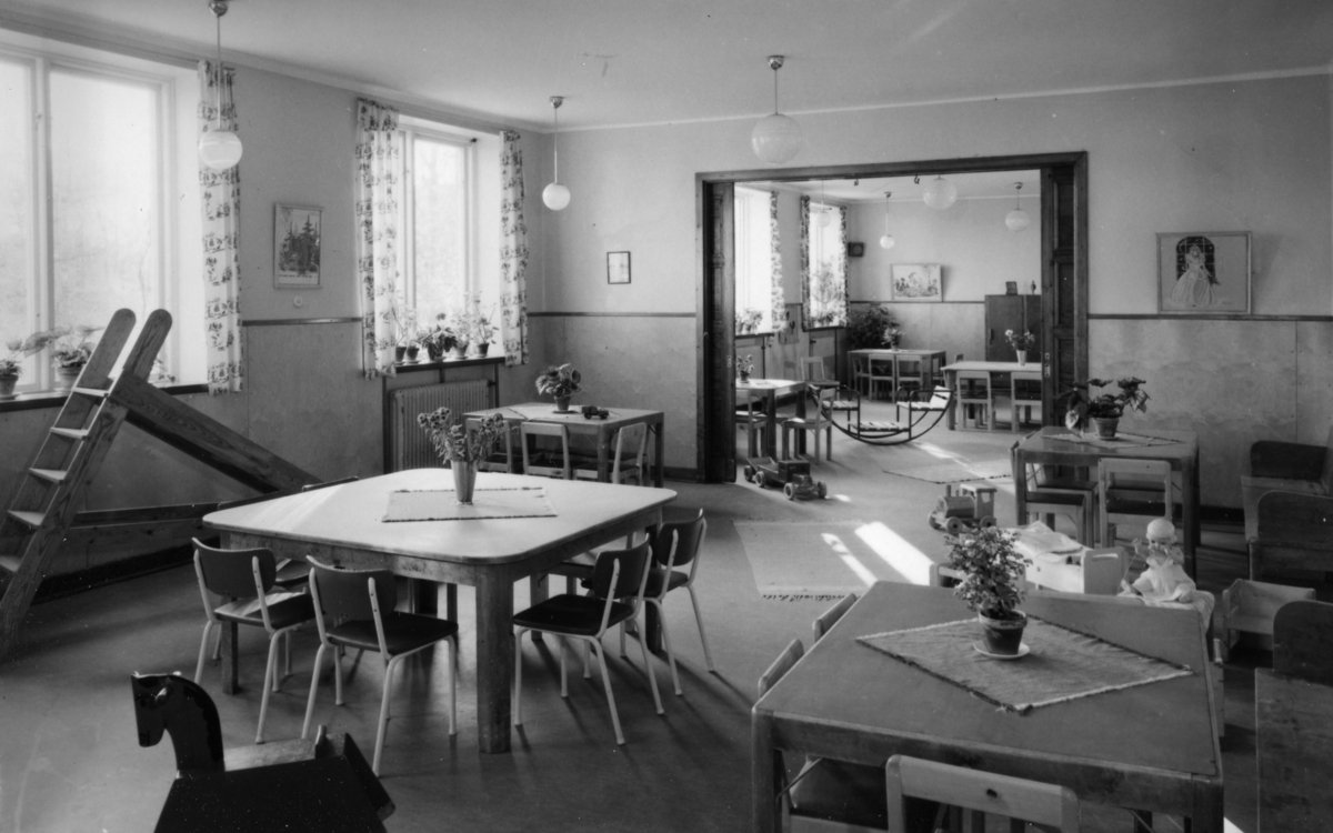 Vykort från dagrummet i förskolan i Stretereds skolhem (nuvarande Videgården), 1950-tal. Olika leksaker finns på golvet.