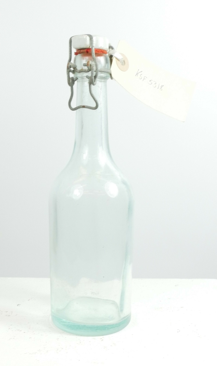 Klar glassflaske med hvit porselenskork med gummi og feste i metall. 