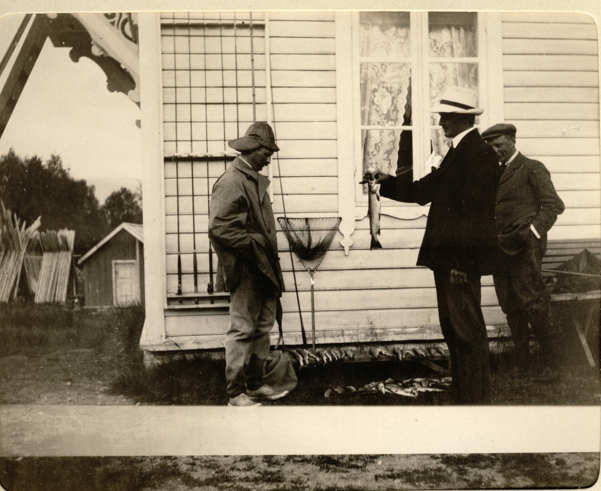Tre menn foran våningshus, antagelig en del av Mølmen skysstasjon i Lesja. De to mennene til høyre er Waldemar Kallevig og Hans Finne. Fotografert 1914.