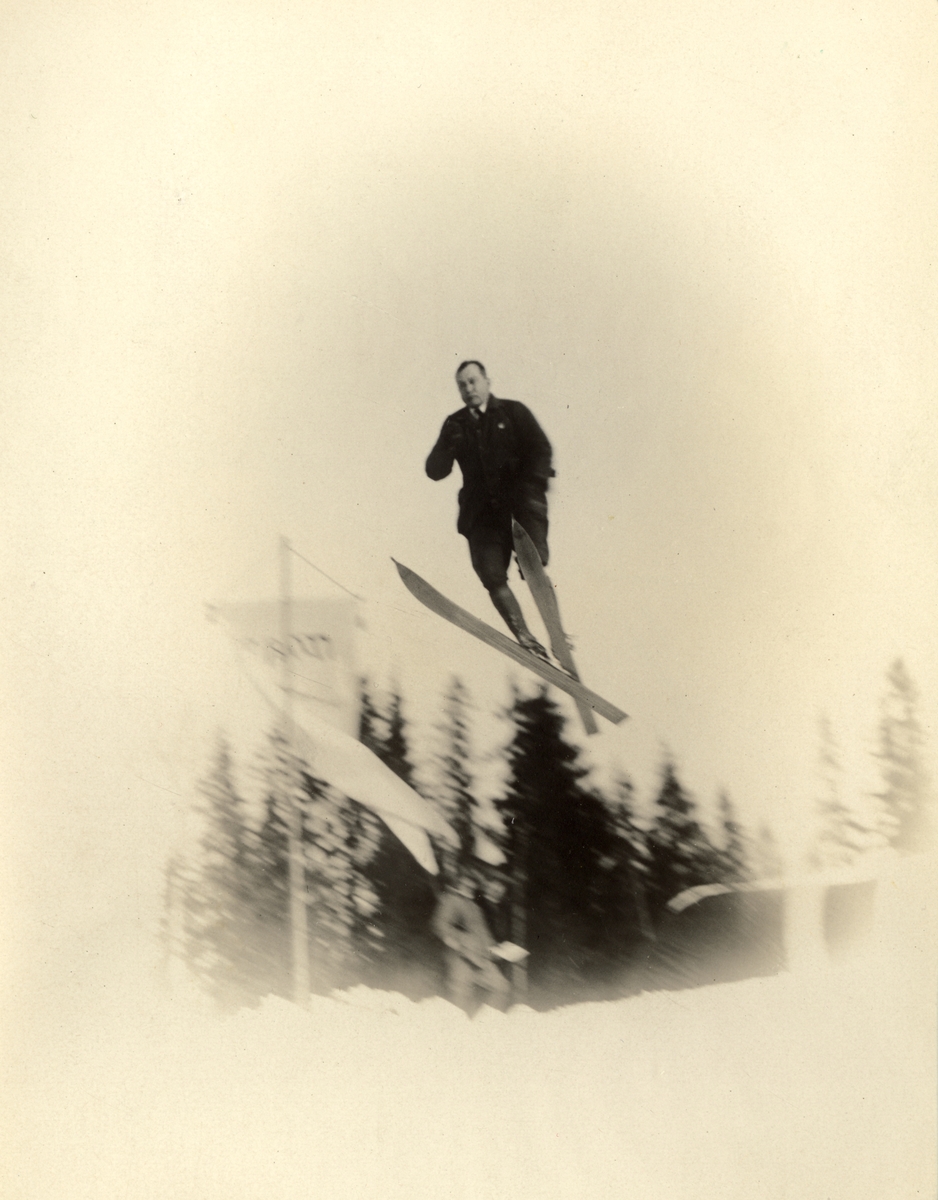 Medlem av skiklubben Fram, Thomas Fearnley, hopper på ski. To tilskuere skimtes nederst. Fotografert 1916.