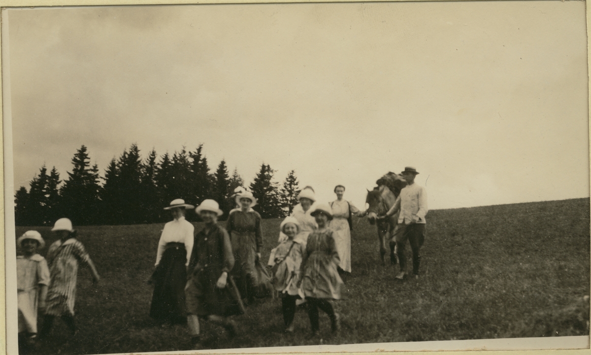 Kvinner og jenter på blåbærtur til Høiåsen ved Bogstad gård. En mann med kløvhest følger bak. Fotografert 1919.