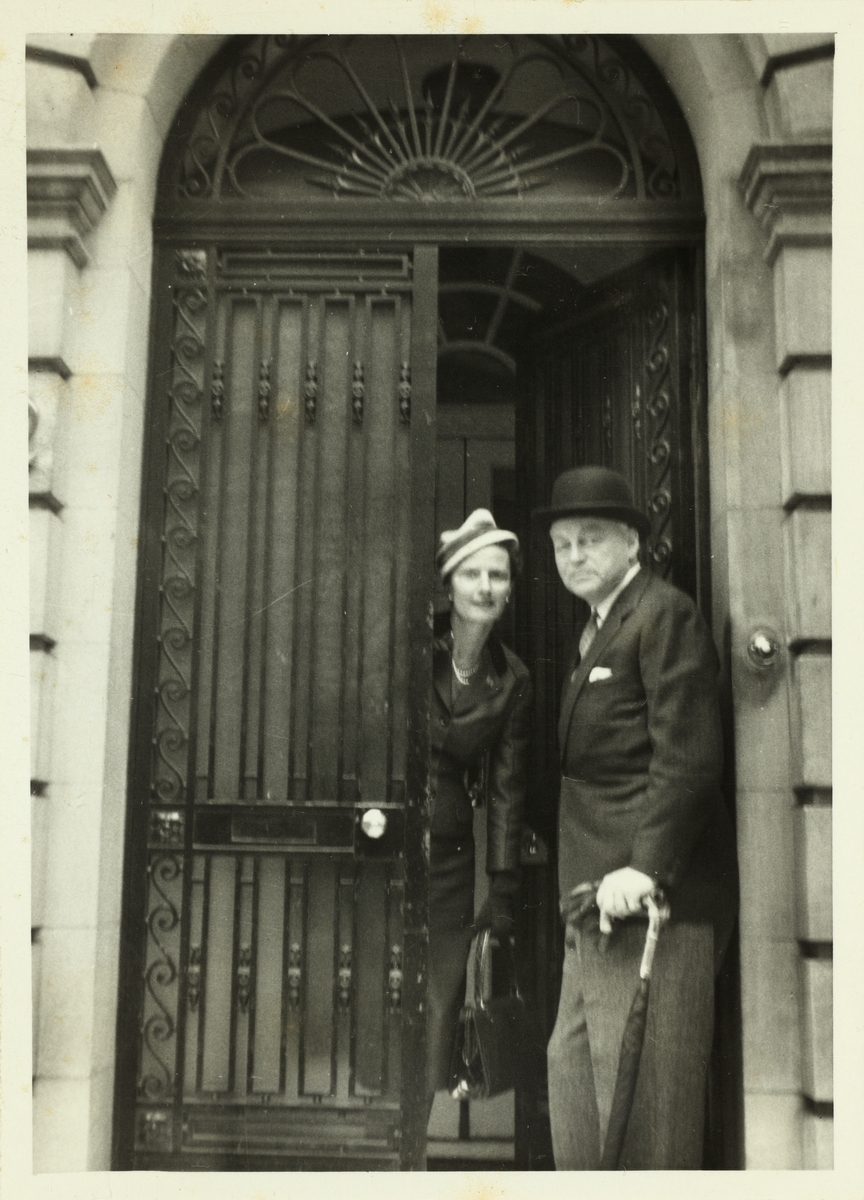 Lucy og Leif Høegh i døråpning til 42 Upper Brook Street. På reise i London i forbindelse med Westye Parr Egebergs 80 års feiring. Fotografert april 1957.