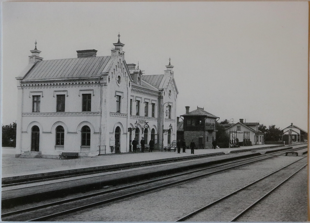 Järnvägsstationen, Enköping, år 1906.

Järnvägsstation och järnvägen invigdes av Oscar II den 12 december 1876, med det nybyggda stationshuset som även fungerade som postkontor. Järnvägsstationen brann ned 1884 och nytt stationshus byggdes upp på samma plats 1885, vilket är det hus vi ser på vykortet och detsamma som står kvar än idag.