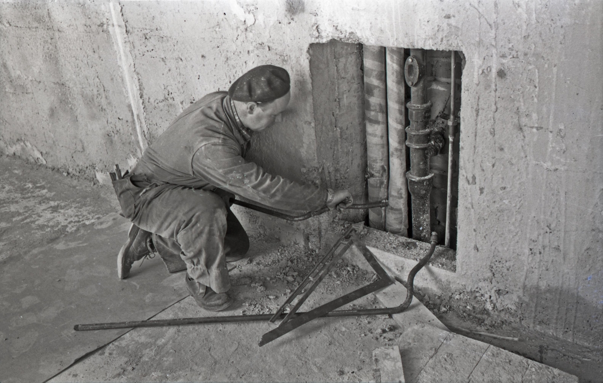 Rørlegger i arbeid under renoveringen av Hauge skole, ca. 1955.