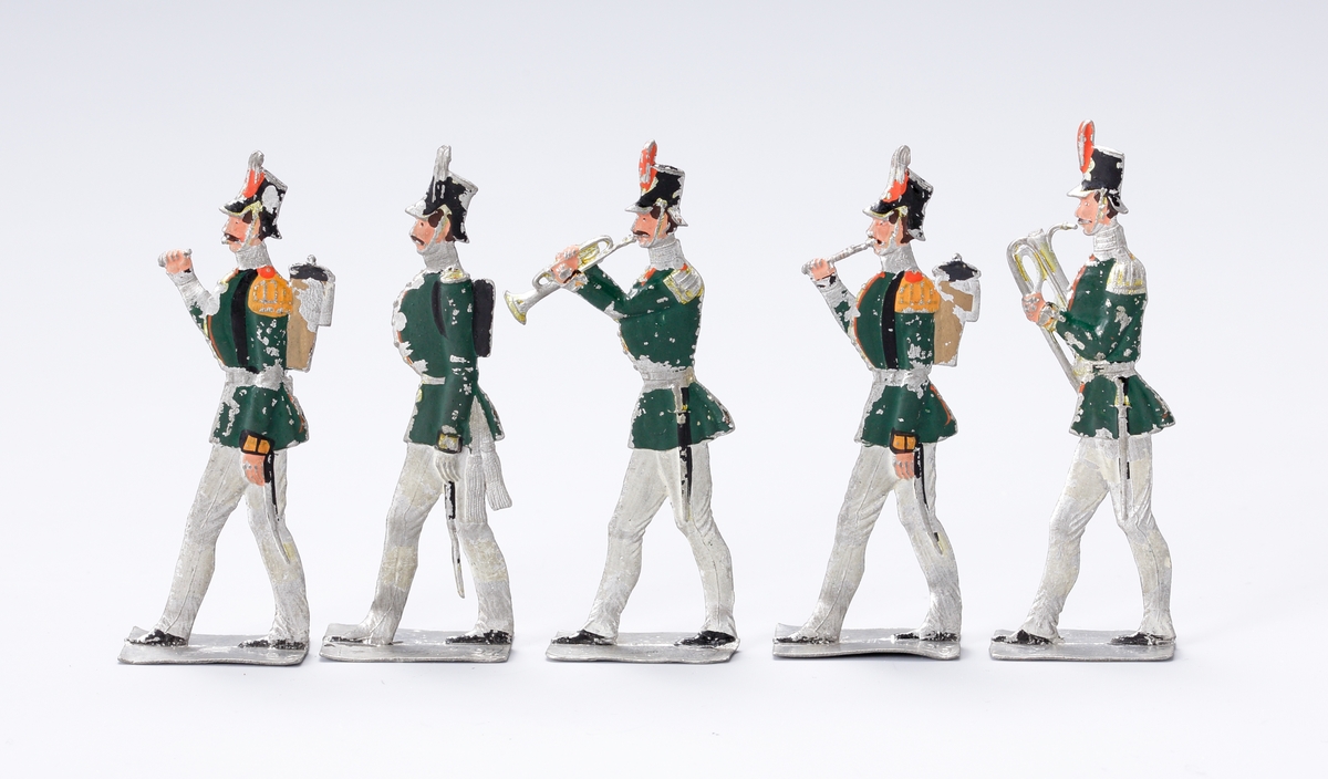 Flöjtblåsare, del av en militär musikkår. Uniform i grönt och vitt av sent 1800-talssnitt.
Inskrivet i huvudbok 1937.