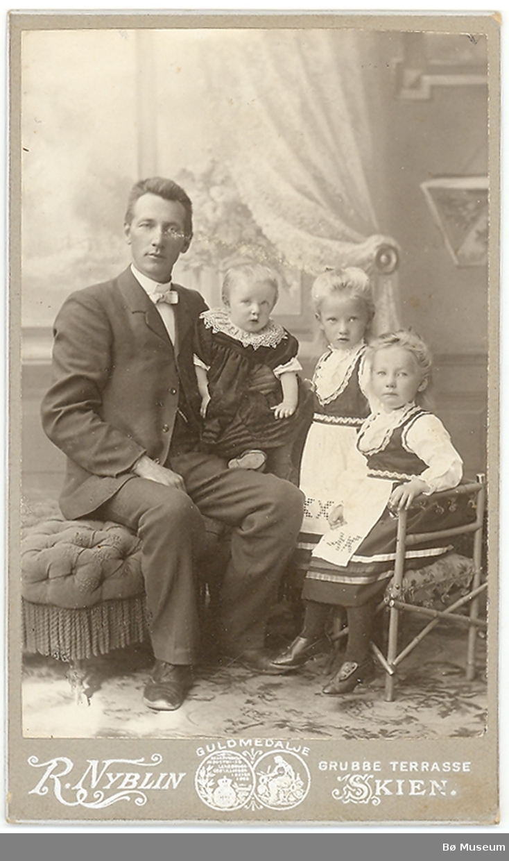 Mann med tre barn i fotoatelier