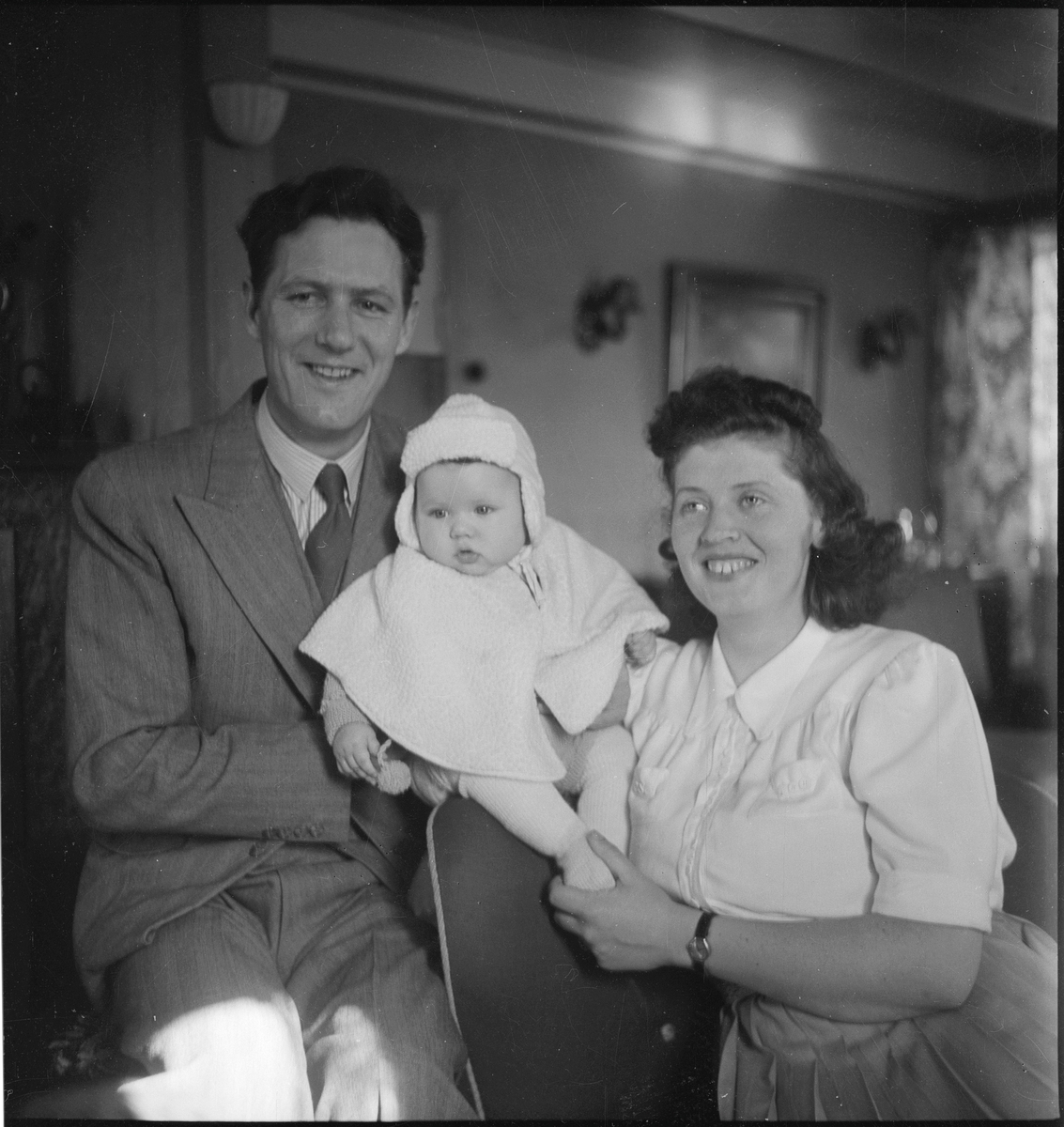 Portrett av en liten familie, med far, mor og en liten baby.