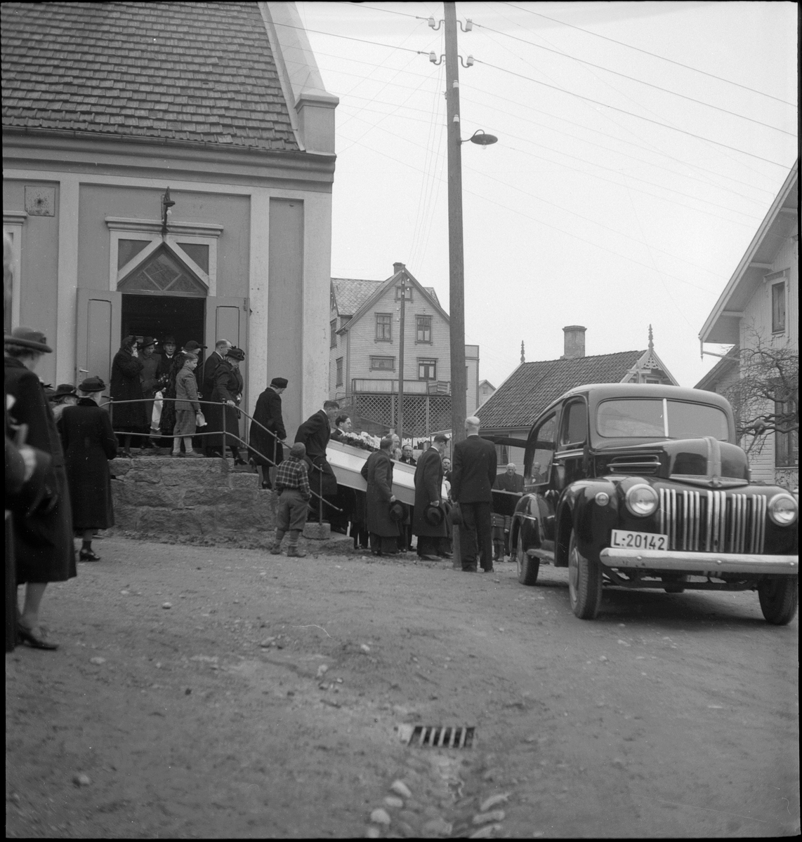 Begravelse i nærheten av Egersund. Det er bilder av kista med blomster, og av seremonien med folk som følger den døde til graven.