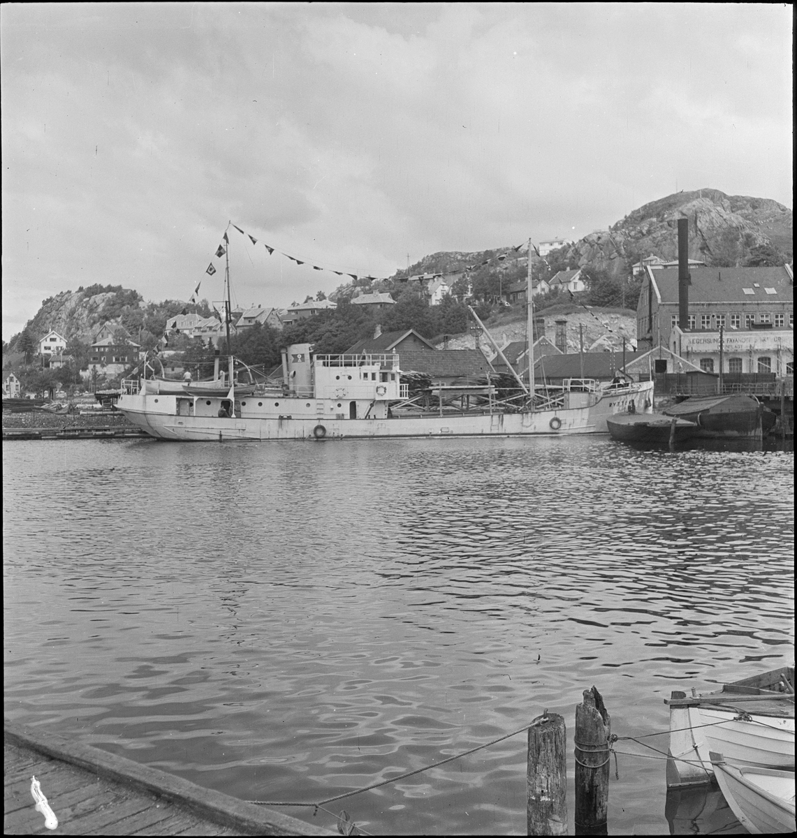 Stykkgodsskipet "M/S Rytter" ved kai i Egersund. Skipet er pyntet med vimpler.