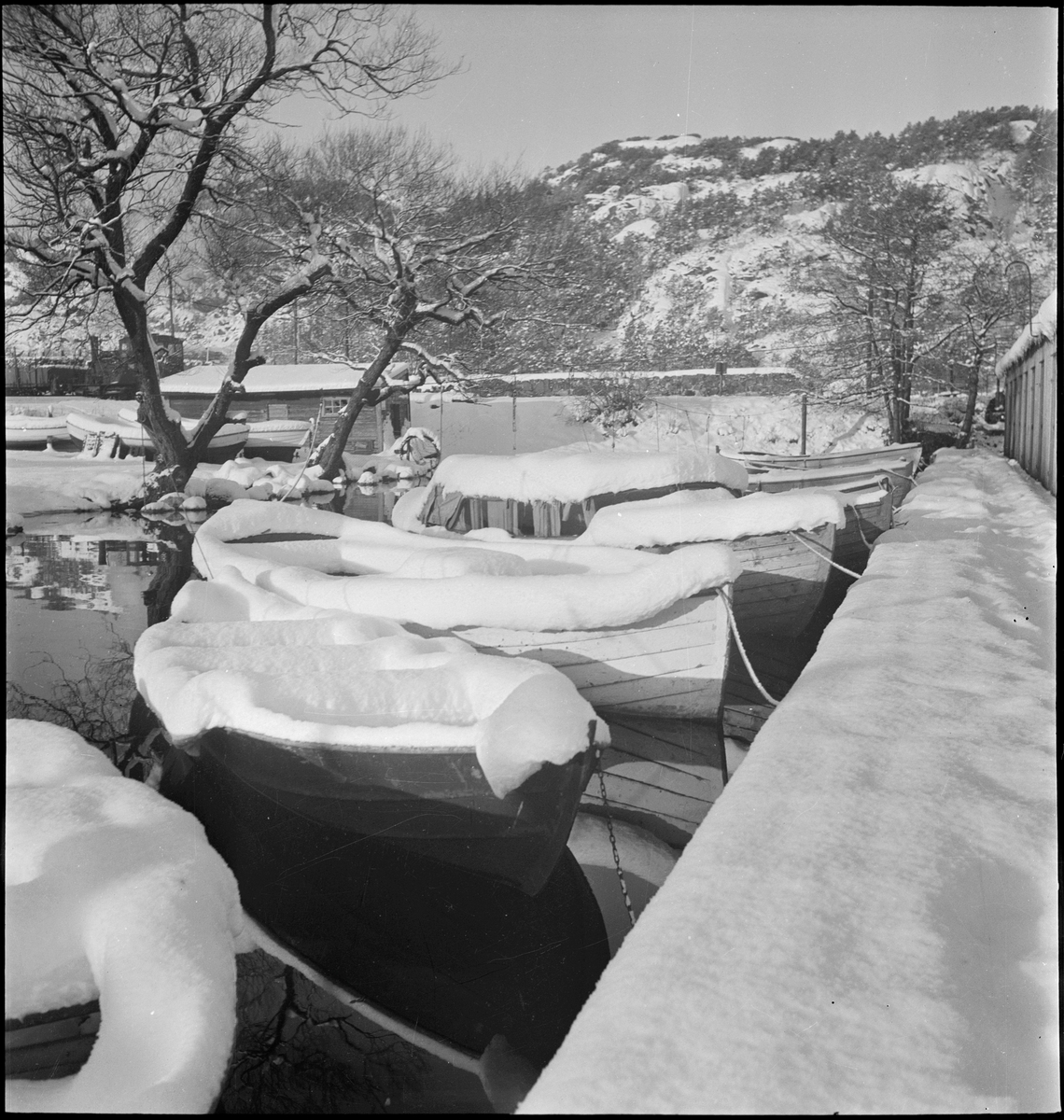 Julehilsen fra Fothuset A/S i Egersund. Småbåter er dekket med snø i ved båthuset i Lervika