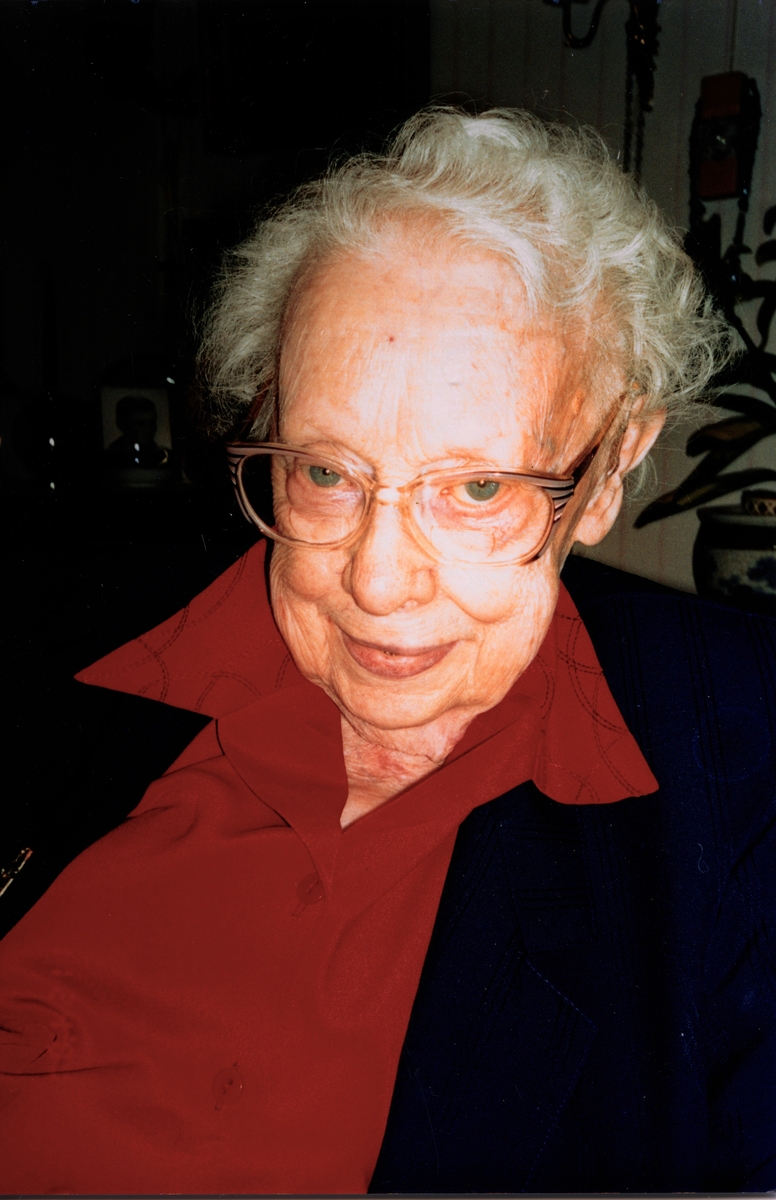Greta Alm Andersson (född 1901, död 2005) firas i sin lägenhet på Brattåshemmet då hon fyller 100 år. Hon arbetade som småskollärarinna i Kållered 1928 - 1962 och var gift med Georg Andersson. Relaterat motiv: A1997.