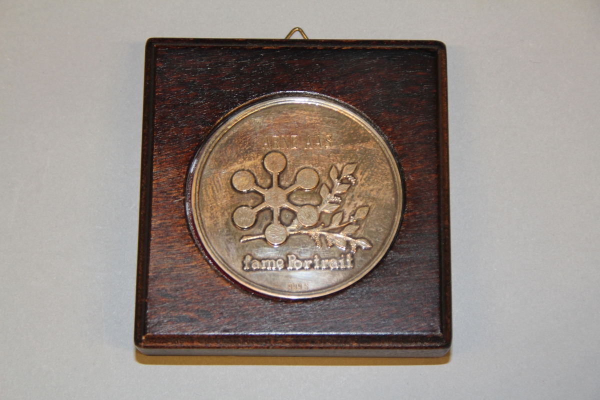 Sølvmedalje "Fame Portrait" Medlaja ligg i i ramme av tre, trekt med raud fløyel. Ramma er litt tjukkare i øvre kanten.