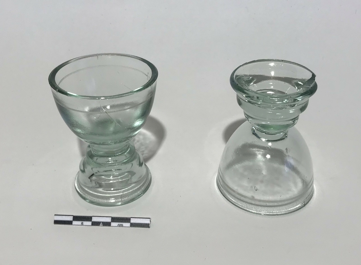 2 små shotglass med stett. Det er merket en strek for 2,5 cl rundt glasset.