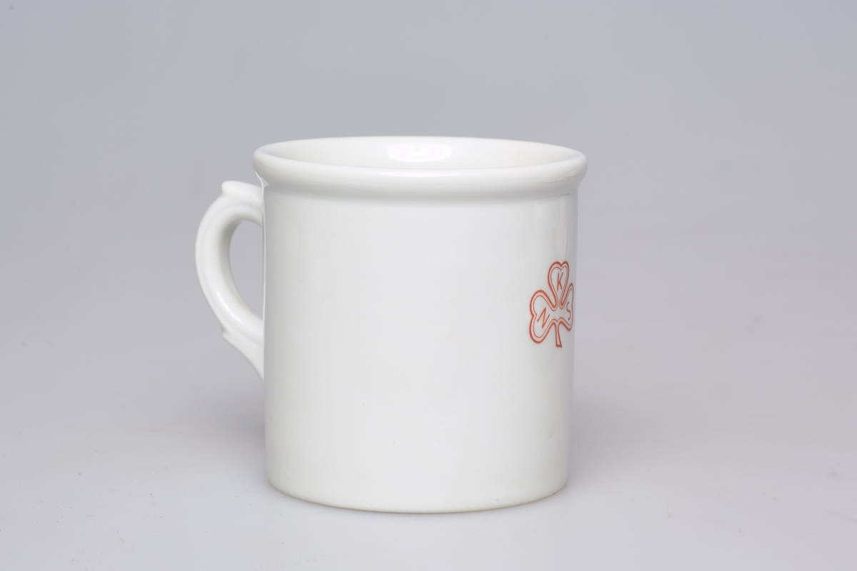 Stor kopp i porselen, med hank og logoen til Norske kvinners sanitetsforening. 