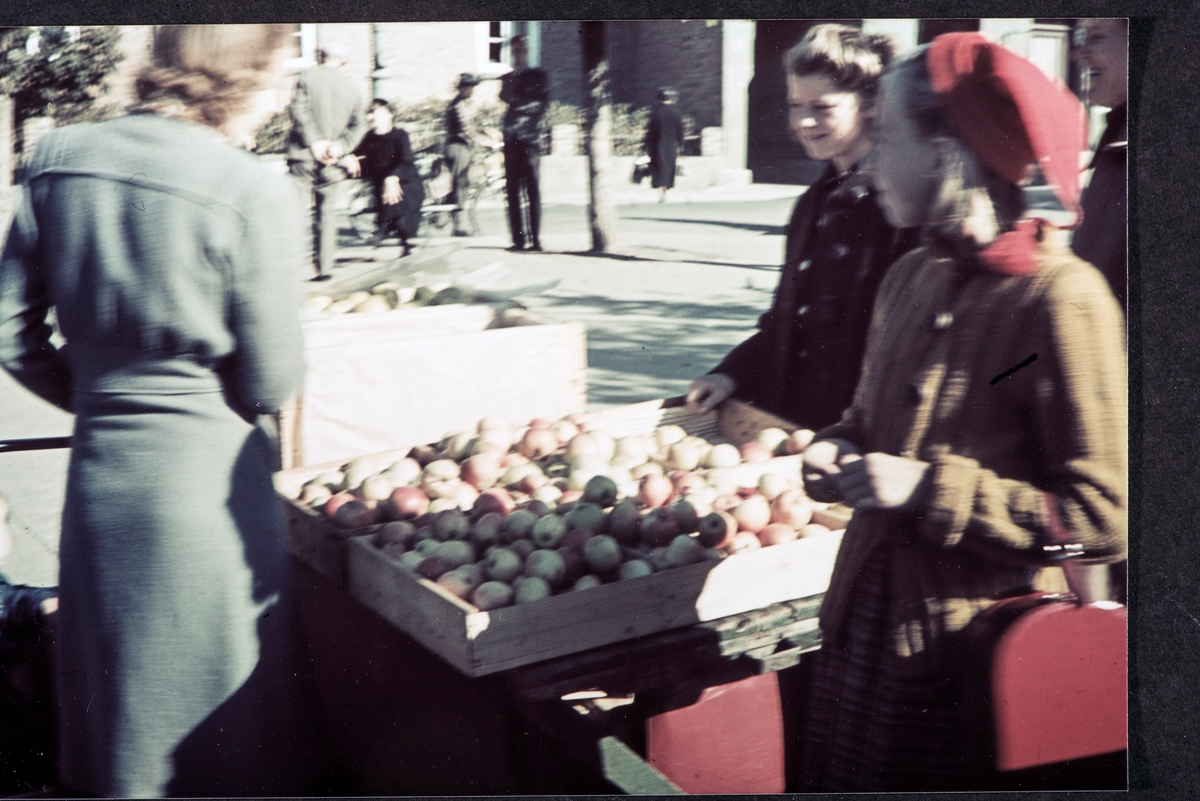 Stortorget, Hamar. Torghandel, epler, frukt.  Torghandler Anna Olsen selger epler. 1941-42. 2. verdenskrig. Kvinne med nisselue, rød skoeske.