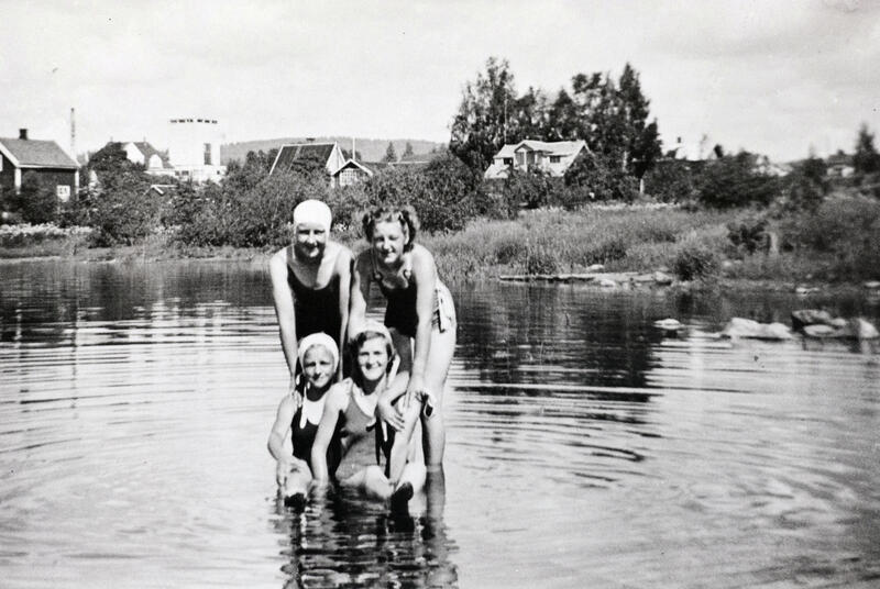 Svart-hvitt foto av fire unge damer med badedrakt og badehette ute i Mjøsa. (Foto/Photo)