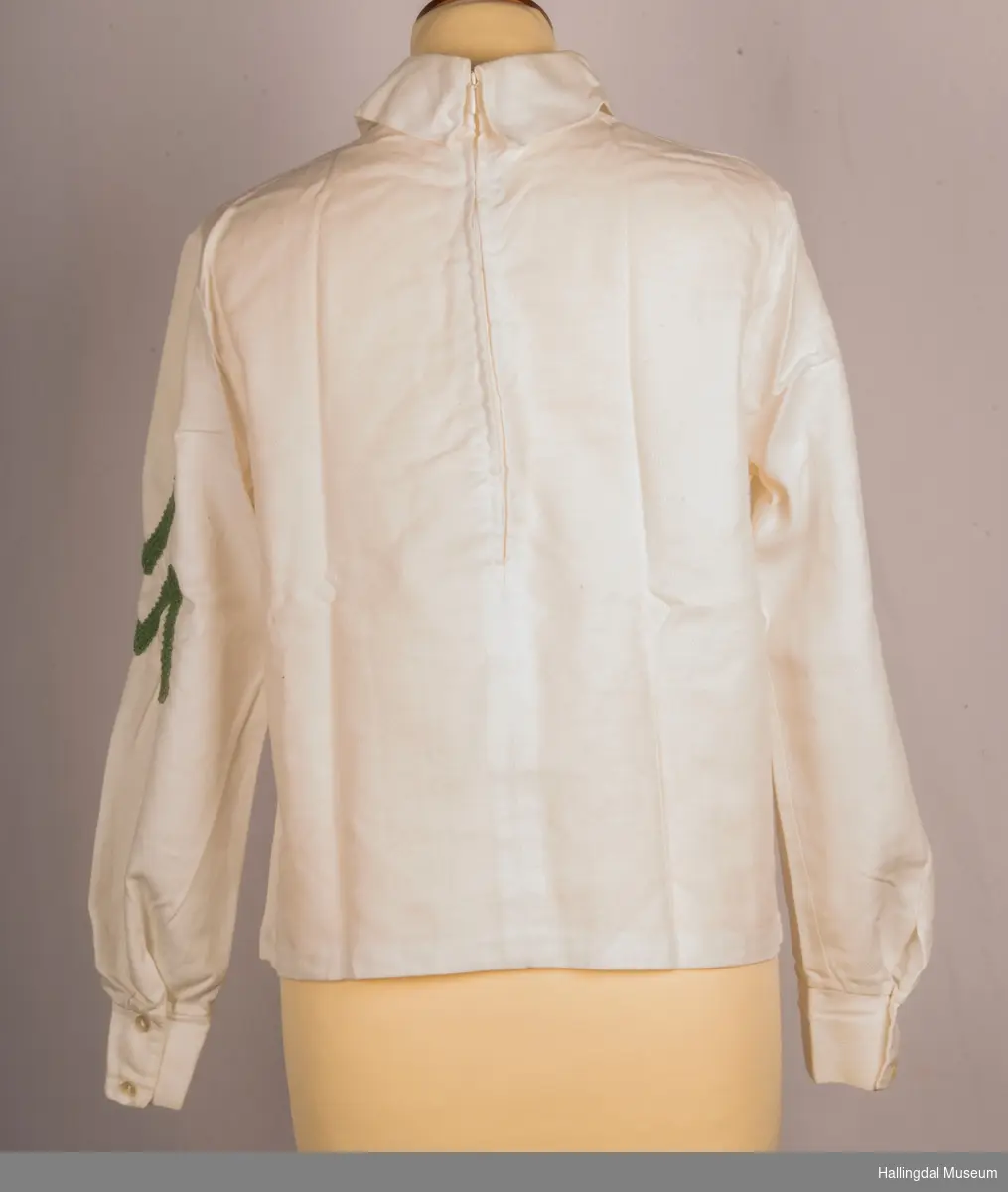 VM bluse som hører til drakt HFN 14365 a+b
60-tallet
Skjorte, bluse med høy krage, glidelås bak.