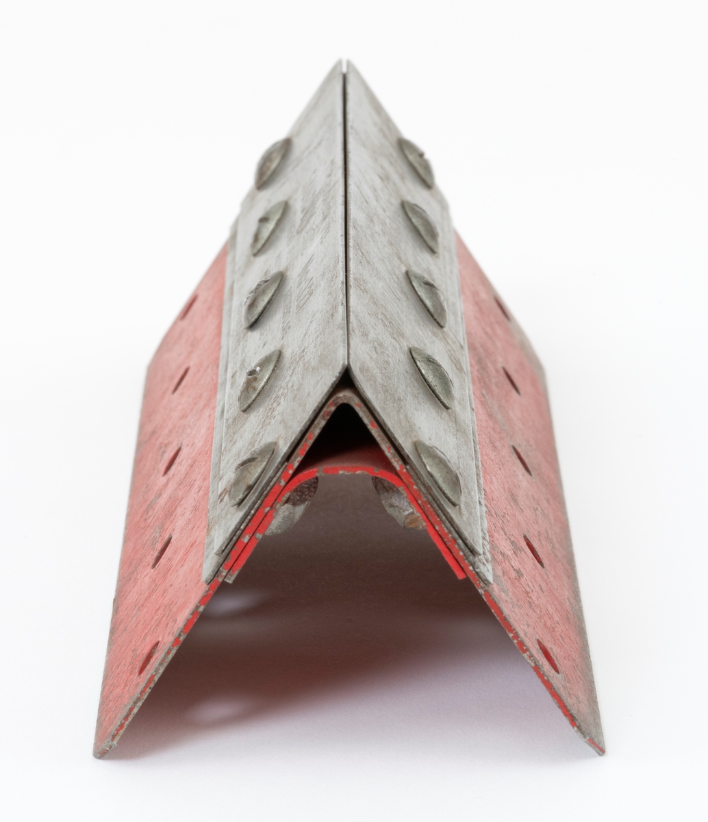 Klemme, filklemme, av typen Sandvik 127 for sagblad (buesagblad, bogesagblad) til buesager (bogesager). For å ha begge hender frie under filing av sagbladet festes det i en holder (klemme). Filklemma er konstruert av stålplater.  En rød rektangulær stålplate er bøyd (knekt) slik at en får to sider. Sett fra kortendene gir det filklemma en trekantete form. I den røde stålpata er det 5 hull på hver side. (Her kan det f. eks. slås inn spiker for å feste klemma til en stubbe i skogen når en vedlikeholder bladet.) Under den bøyde plata, er det påskrudd en ståplate som avstiver konstruksjonen. Utenpå klemma er det, på begge sider, festet to grå rektangulære stålplater. Hver enkelt plate er skrudd fast med 5 sporskruer. Disse skruene holder også fast den avstivende plata på undersiden. Ved å løsne litt på skruene, tre bladet mellom de grå ståplatene og deretter stramme til igjen, festes sagbladet som skal files.