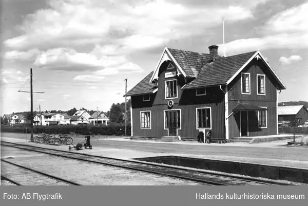 Ullareds järnvägsstation sedd från spårsidan. I bakgrunden ses bostadshus och andra byggnader.