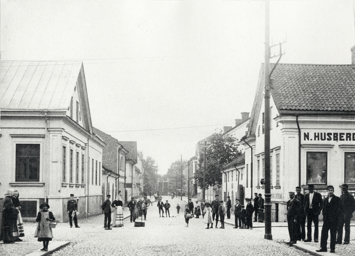 Korsningen Storgatan - Klostergatan, Växjö. Vy söderut mot järnvägsbron, 1905. 
Till vänster ser man Lindgren & Brandts fastighet, Storgatan 7 (kv. Unaman nr 1), följt av Unaman nr 5. Till höger Storgatan 9 (kv. Blenda nr 4).