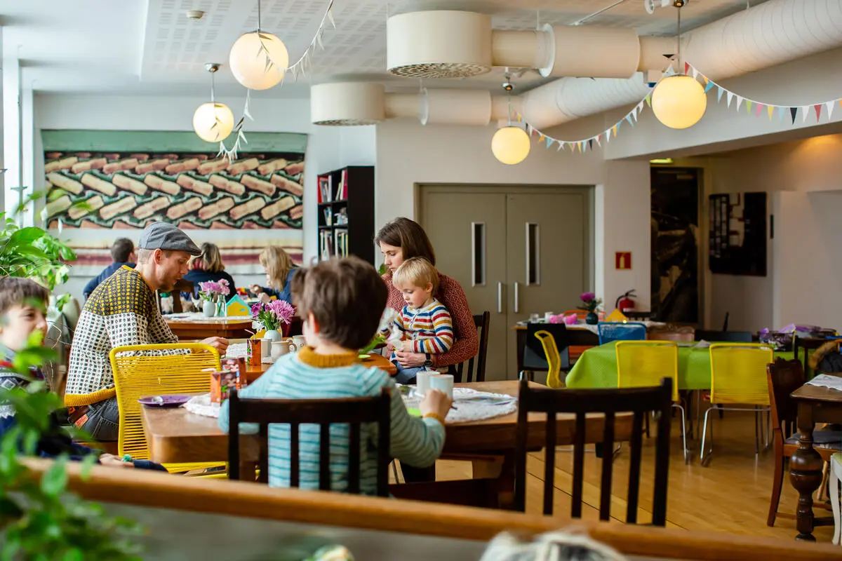 menneske i kafé, lamper og vimplar i taket