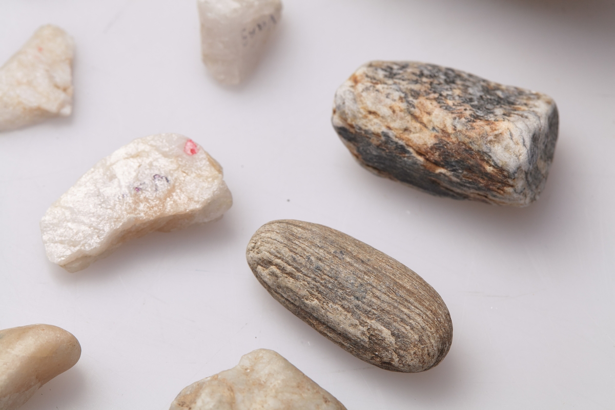 14 små steiner, noen kvite, de fleste gråaktige, på noen av steinene har Johs. Sivesind skrevet "Vang".