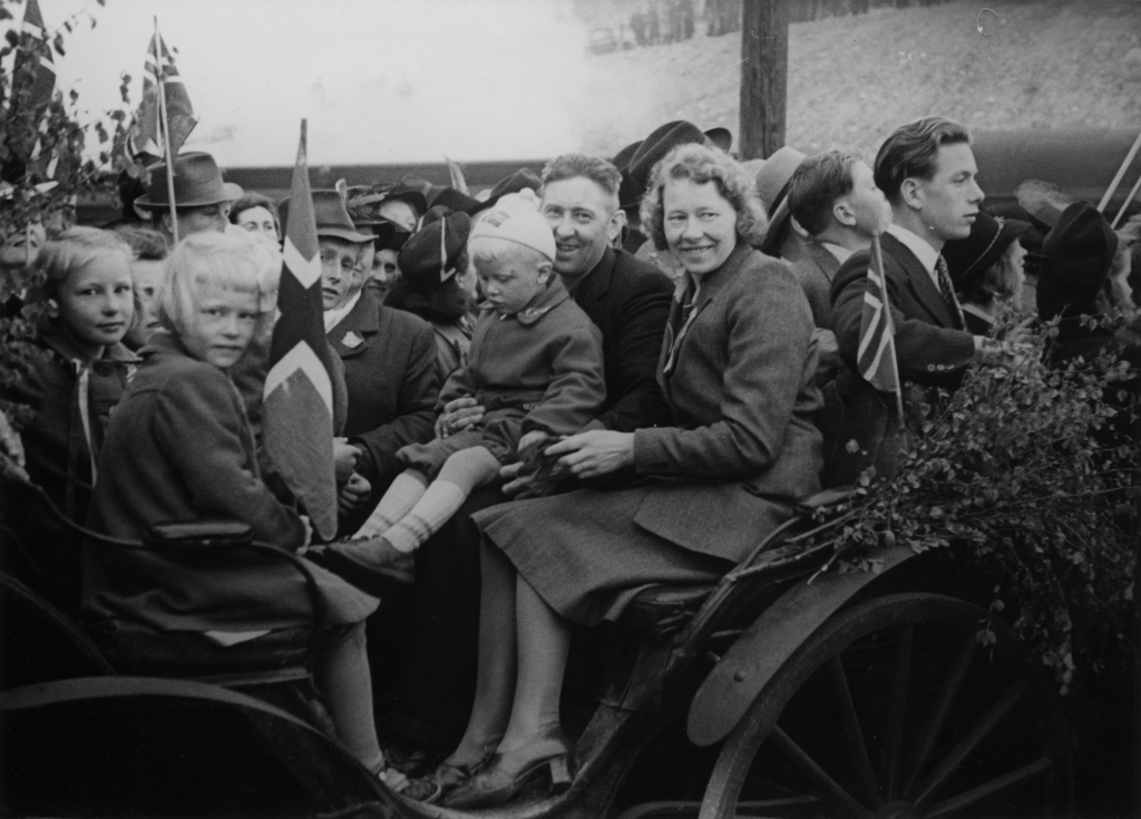 Grinifangene kommer hjem, 10. mai 1945. I vognen sitter Erling Midtbø m/ familie (kona Oddbjørg og 3 barn).