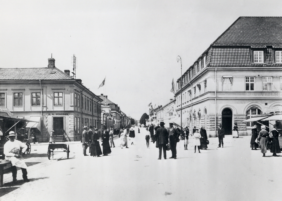 Stortorget, Växjö, en torgdag ca 1918-20. Storgatan mot väster, med dåv. P.N. Perssons hörna till vänster 
(kvarteret Unaman 2) och Skånska bankens fastighet till höger (kvarteret Sunaman 3).