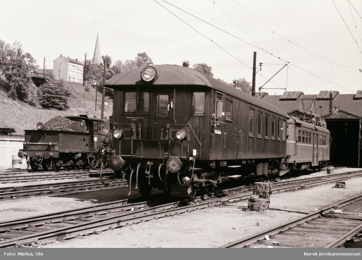 Styrevogn litra BFS65 nr. 18601 eller 18602 og elektrisk motorvogn BM 65 C i Lodalen i Oslo. Bak til venstre damplokomotiv type 21e nr. 207
