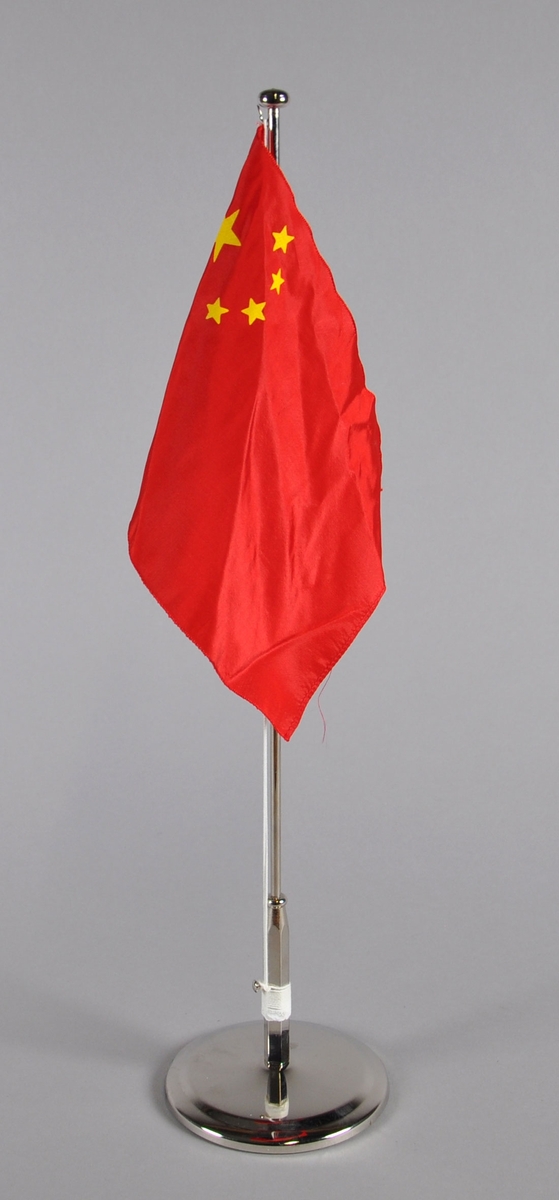 Bordflagg på stang fra Kina. Rødt flagg med fem gule stjerner i det øverste hjørnet nærmest stanga.
