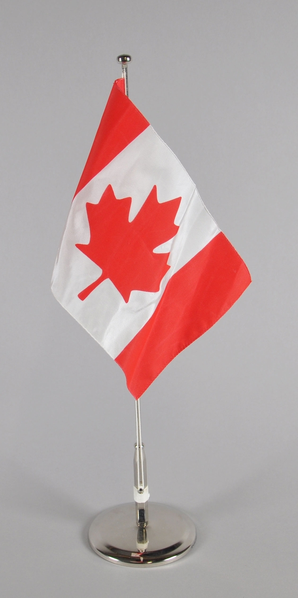 Bordflagg med stang fra Canada. Rødt og hvitt med lønneblad i rødt på hvit bakgrunn.