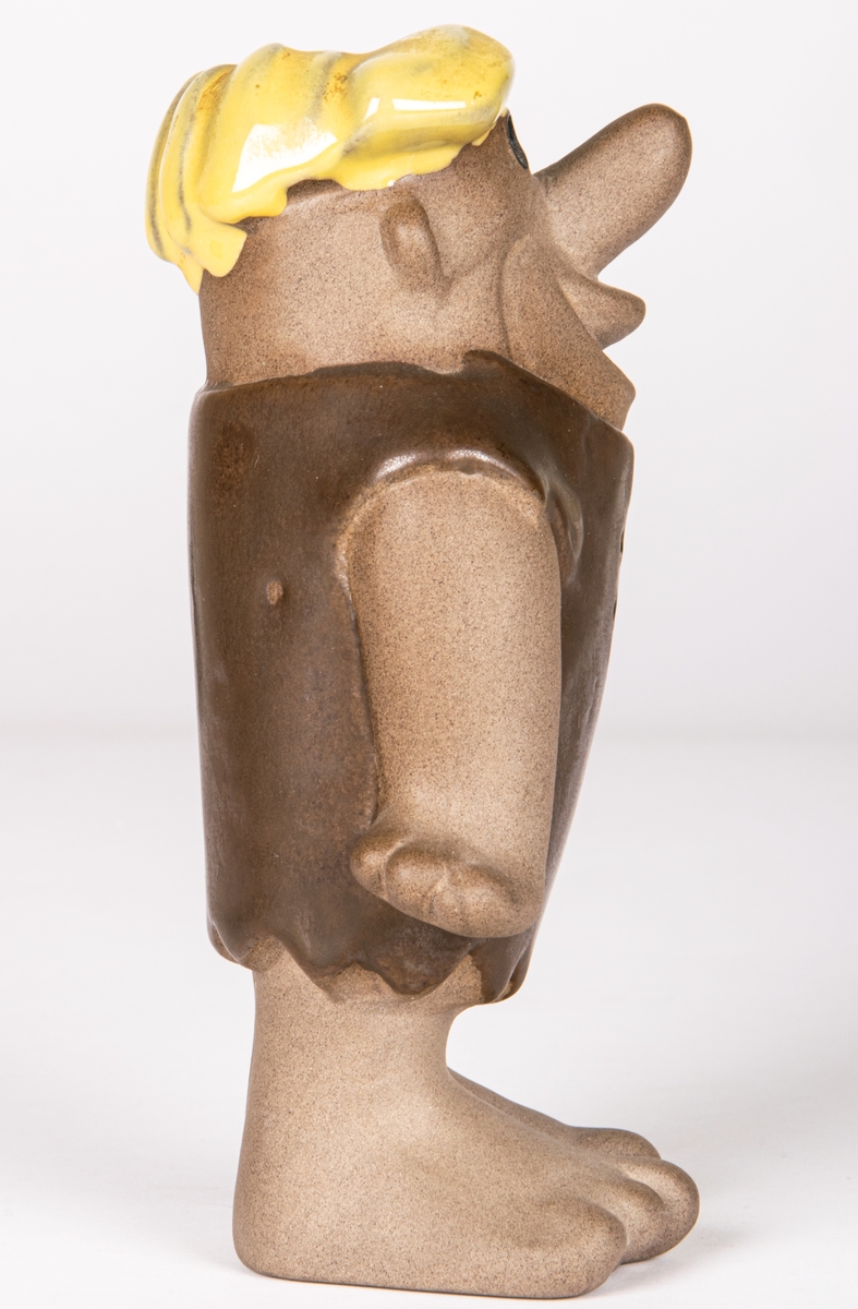 Figurin i flintgods föreställande Barney Granit ur serien "The Flintstones". Formgiven 1957 för Gefle porslin. Detta ex tillverkat mellan 1961-1971 enligt stämpeln.